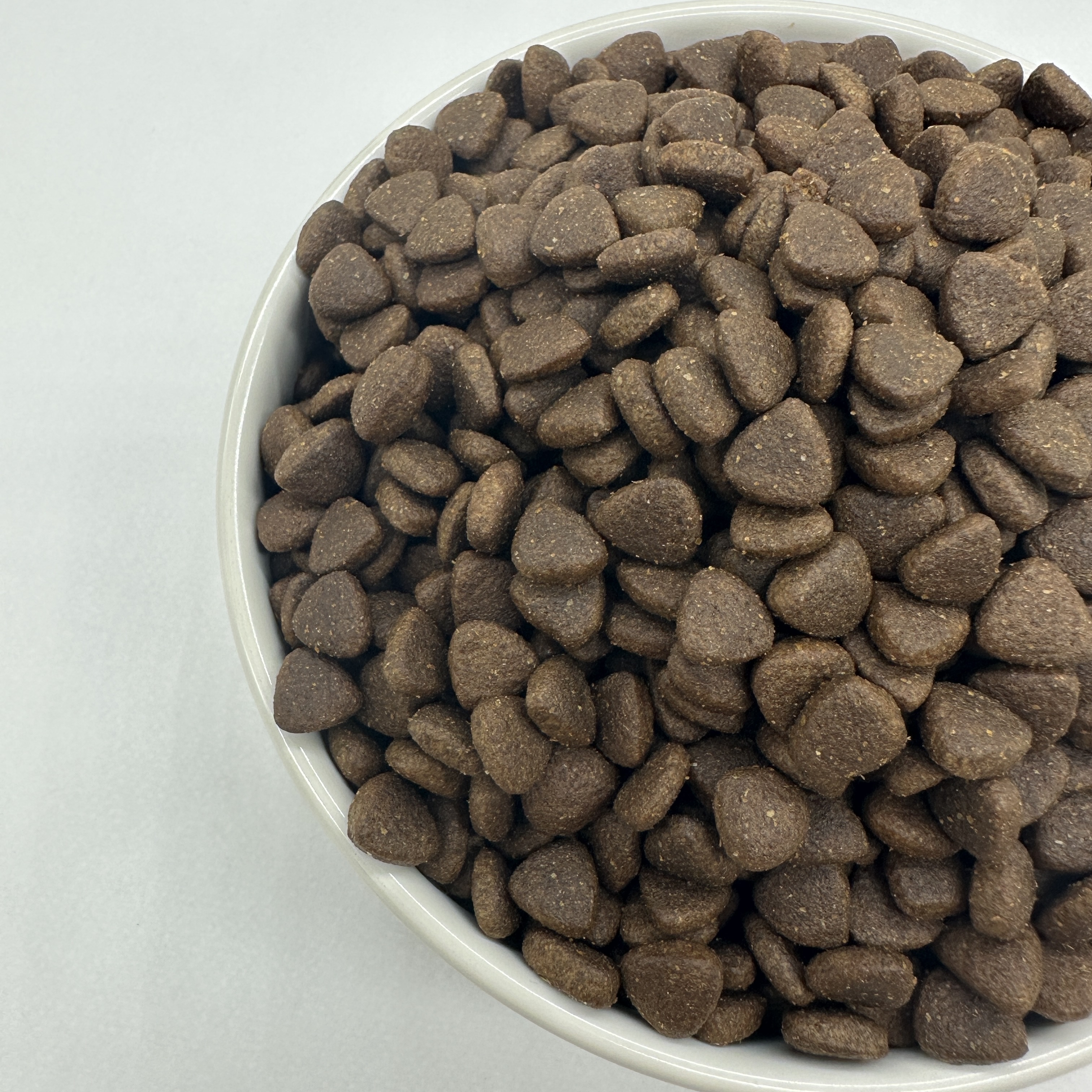 Croquettes AMD Dog Food dans une assiette en bois